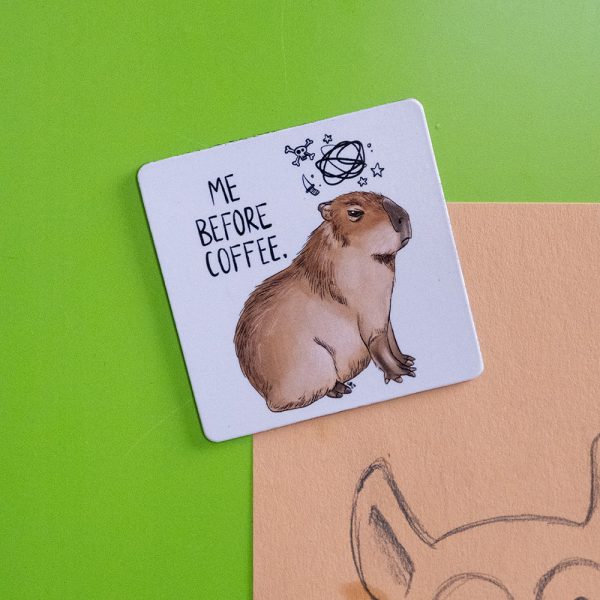 Ein Capybara mit bösem Gesichtsausdruck und dem Spruch "Me before coffee."